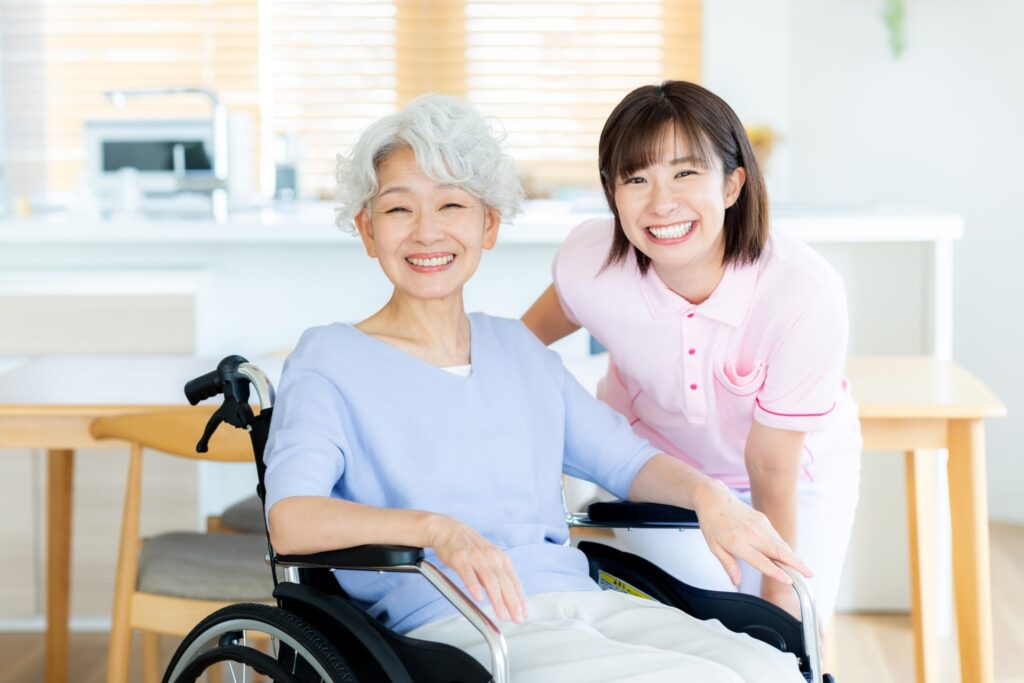 笑う女性介護士と高齢女性