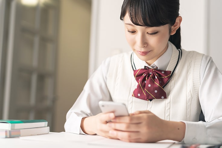 A female student operating a smartphone