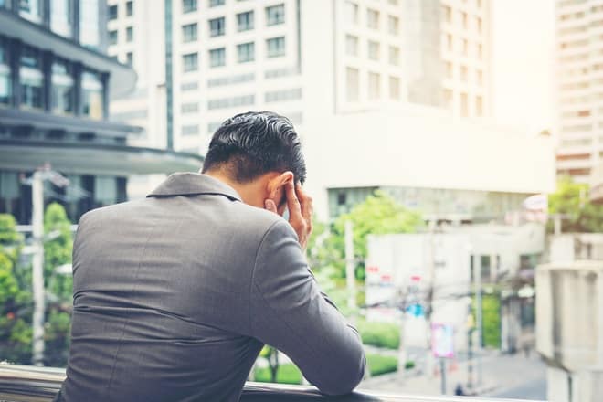 男性が手すりにもたれかかっている