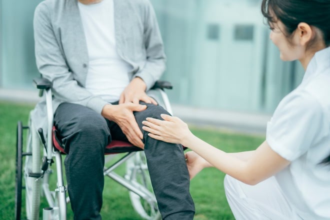 車椅子に乗った男性と介護する女性